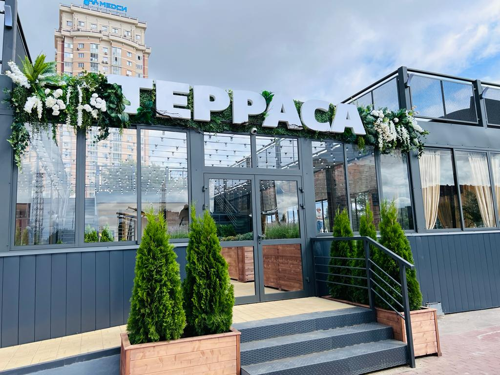 Вход в ресторан «Терраса» с вывеской и зеленью